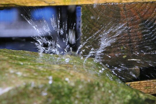 Heavy rain falls on a stone, and the drops burst