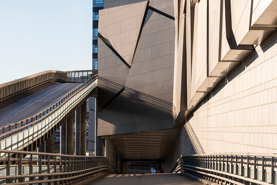 Angular architecture in Stockholm Sweden channels a concrete ramp road below an urban transport facade, with railings fading into shadow
