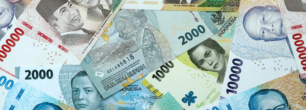 Indonesian rupiah money banknotes pile on table. Indonesia bills of IDR currency close up