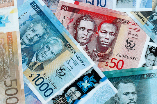 Jamaican dollar money banknotes pile on table. Jamaica bills of JMD currency close up