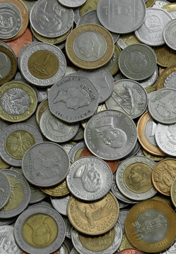 Top view of assorted coins, numerous world currencies together. Shiny metal pieces in mound