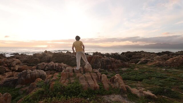 young boy exploring rocky coastline of DeKelders, Gansbaai, South Africa