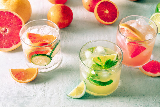 Refreshing summer cocktails with ice cubes on a light background