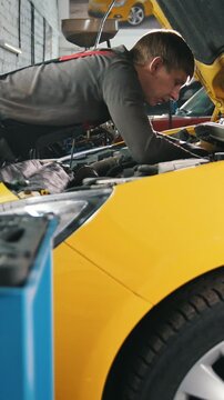 Yellow car in garage auto service - open hood - engine repairing
