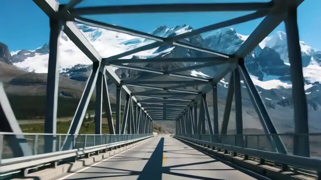 Approaching vehicle entering steel truss bridge in alpine valley to cross gap, showing yellow line
