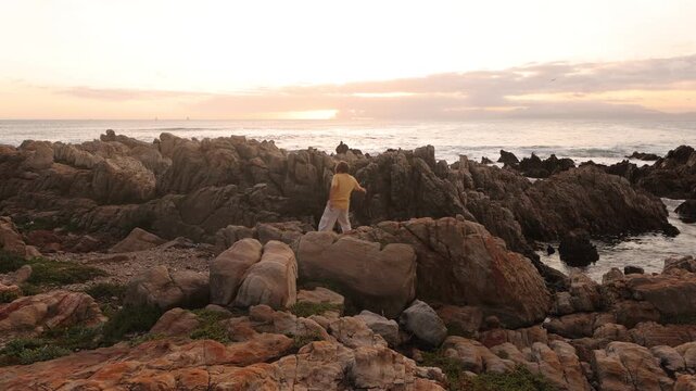 young boy exploring rocky coastline of DeKelders, Gansbaai, South Africa