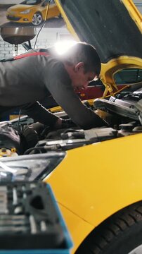 Yellow car in garage auto service - open hood - engine repairing