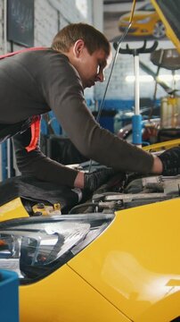 Mechanic in car service - repairing in engine compartment