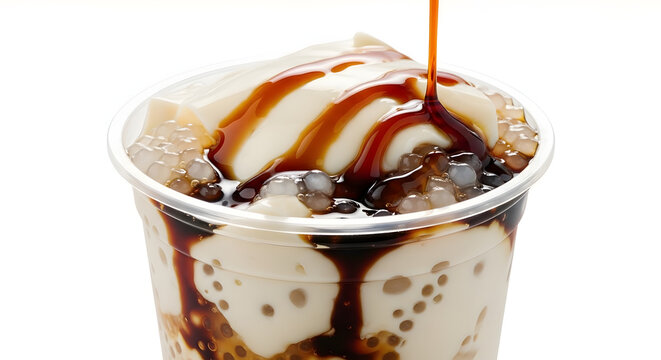 Eye level shot of taho a Philippine dessert made from silken tofu with sago pearls being poured with arnibal or brown sugar syrup on white background. Suitable for food catalog or Asian food ideas