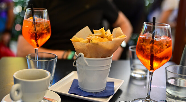 Aperol Spritz and ,cacio e pepe fried  potatoes tipical italian snack for aperitivo in a bar in ,Rome, Italy