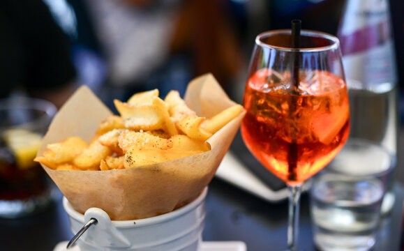 Aperol Spritz and ,cacio e pepe fried  potatoes tipical italian snack for aperitivo in a bar in ,Rome, Italy