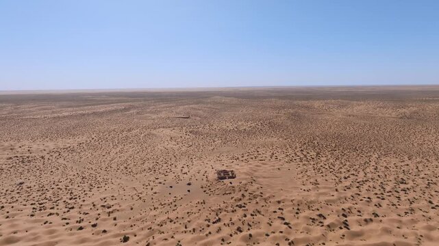 Aerial drone view of the ancient Tisavar Fort ruins near Ksar Ghilane Oasis in the Tunisian Sahara Desert. Historical Roman outpost surrounded by arid sand dunes and vast desert landscape