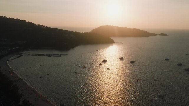 Static aerial view of Phuket bay with boats and parasailing at sunset
