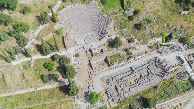 Aerial drone shot showing the historic ruins of the ancient theatre and temple of Apollo at Delphi, a famous archaeological site and popular tourist attraction on the slopes of mount Parnassus