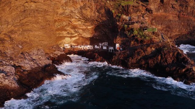 Cueva Poris de Candelaria, fishing village tucked inside massive sea cave on coast of La Palma, Spain, aerial reveal