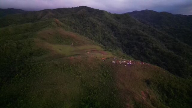Stunning aerial overview of hikers and campers gathered atop Mount Lantad in Bato, Catanduanes, Philippines with lush greenery