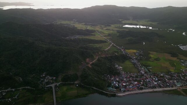 Aerial overview of Bato, Catanduanes with rural villages, mountain terrain, farmland, and tropical landscape during sunrise