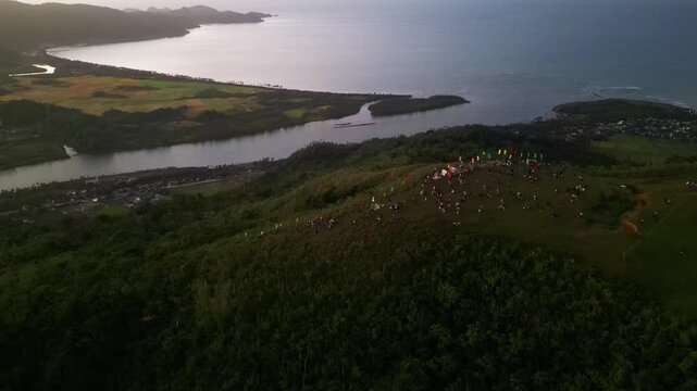 Picturesque aerial dolly shot of hikers gathered atop Mount Lantad in Guinobatan, Bato, Catanduanes during sunrise