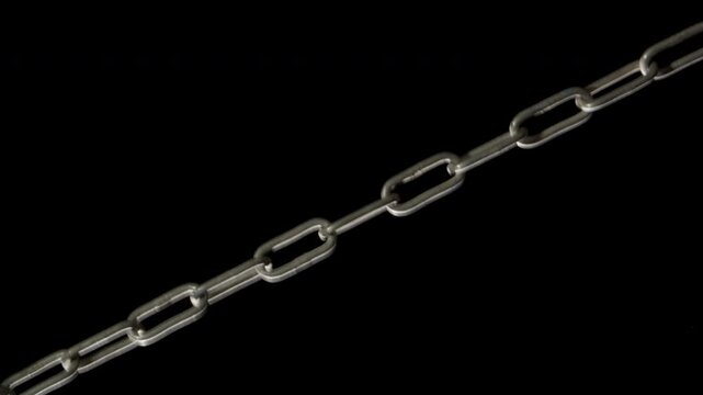 A metal chains get tension diagonally on a black background