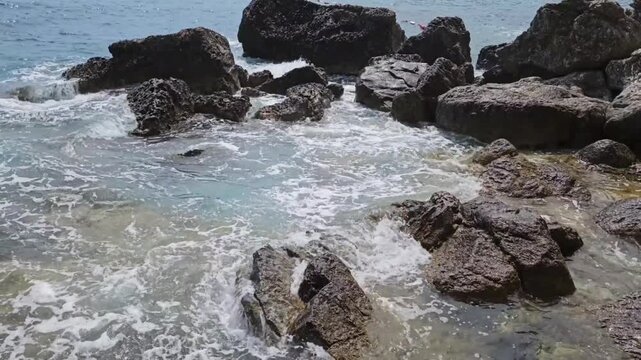 the waves of the Adriatic Sea beautifully break against the rocks and large stones. Beautiful view of the Adriatic Sea and the old town, 
Tourism, beach, active recreation, rocks