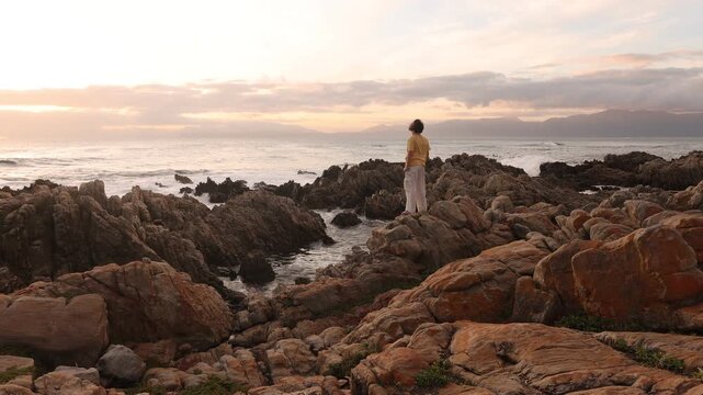 young boy exploring rocky coastline of DeKelders, Gansbaai, South Africa