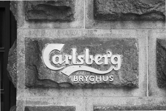 Cartel Carlsberg en fachada de piedra en blanco y negro
