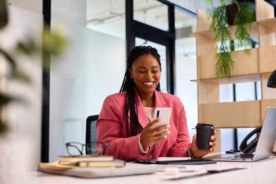 Black business curvy woman using mobile phone at office