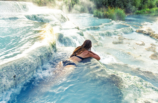woman in bikini relaxing in natural thermal pools of saturnia hot springs in tuscany italy