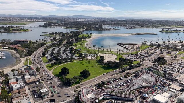 Mission Bay park and Belmont Park's wooden roller coaster from above, green park space beside the historic amusement ride with bay waters in background, San Diego California. Theme Park Rides