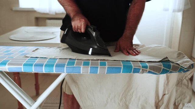 Ironing a light colored garment on a patterned ironing board inside a house