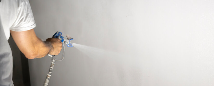 Paint spray application on smooth interior wall with copy space