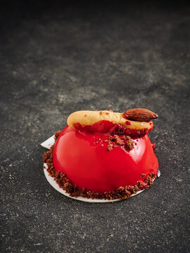 This dessert features a red berry mousse topped with an almond garnish and crumb crust. Ideal for high-end menus, catering events, and gourmet food packaging