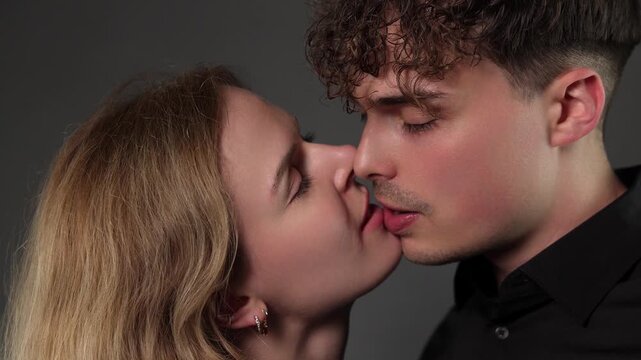Romantic couple kissing passionately, embodying love and intimacy. This close up shot of a young man and woman sharing a tender moment is projects related to relationships, affection, and emotional co