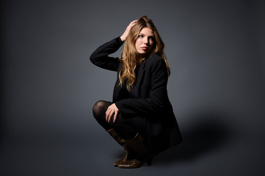 Confident Young Woman Posing Against a Dark Background