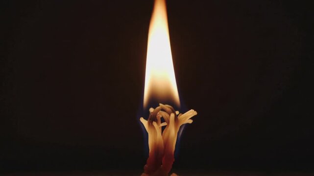 Flickering candle reacting to charred wick heat, elongating flame and melting wax on dark studio