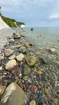 Famous white chalk cliffs and rocky Baltic Sea coastline in Jasmund National Park on Rugen island, Germany. Iconic natural landmark and coastal travel destination concept.