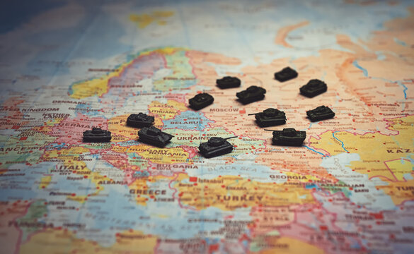 Miniature tanks on Europe map Russia Ukraine war concept.