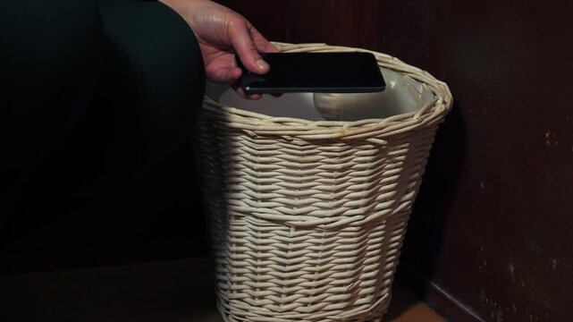 Hands putting mobile phone in the bin