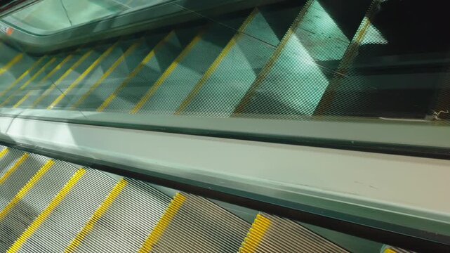 Morning sunlight reflecting across moving escalator in urban interior setting. City lifestyle atmosphere combining transit motion glass reflections and geometric metropolitan design. Modern urban