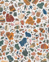 Naklejka premium A vibrant and intricate mosaic pattern featuring a variety of colorful stone fragments embedded in a white background. The irregular shapes and textures create a unique and artistic surface