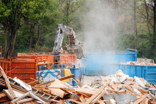Construction site with heavy machinery working on debris removal in a city area during daytime hours