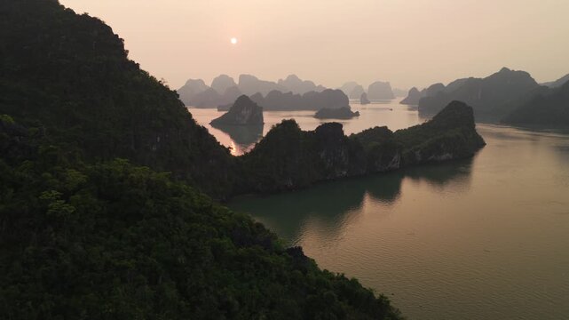 Aerial Flight Reveal Sunset in Ha Long Bay Rugged Stone Isles and Golden Seascape Vietnam