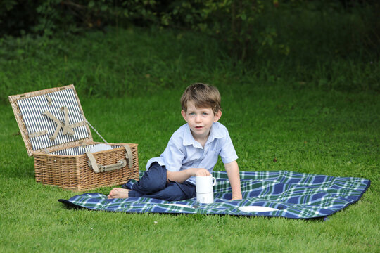 Kleiner Junge mit Picknickkorb im Garten
