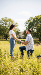 Fototapeta premium Man proposing to woman in a sunlit field with trees, symbolizing love, commitment, and a future together, perfect for engagement or wedding themes