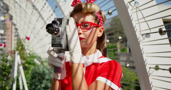 Pinup Style Woman Filming with Vintage Camera Outdoors