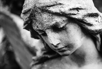 Fototapeta premium Sad angel statue in dramatic black and white close-up composition