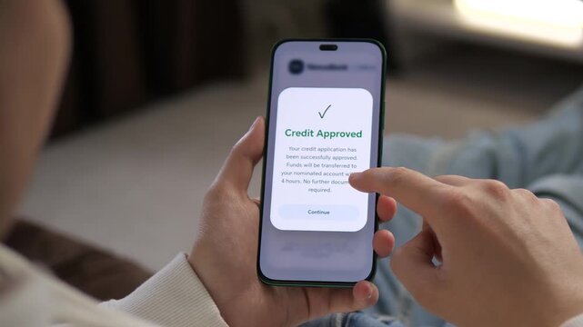 Viewing a Credit Approved notification on a smartphone. The screen displays a green checkmark and confirms successful application. Perfect for fintech apps, digital lending, and personal finance
