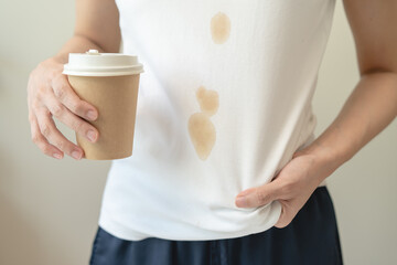 Clothes stain dirty from food concept, people get a coffee drop split from glass on the t-shirt.