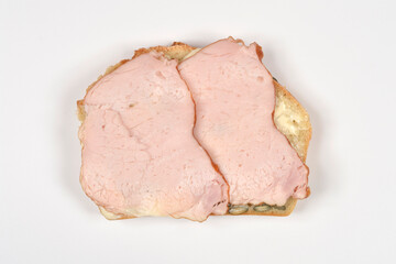 A top down view of a single slice of homemade seed bread topped with two pieces of smoked pork loin isolated on white background © nahhan