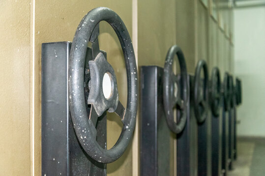 Archive boxes for documents lined up in a storage area with large handles on the front for access